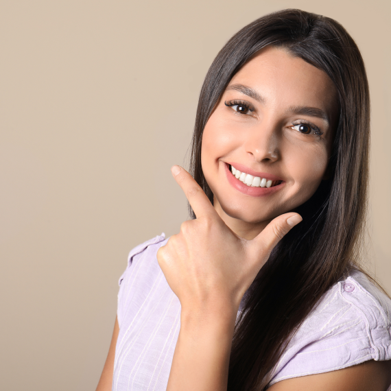 Patient holding up a dental shade guide guide to her teeth